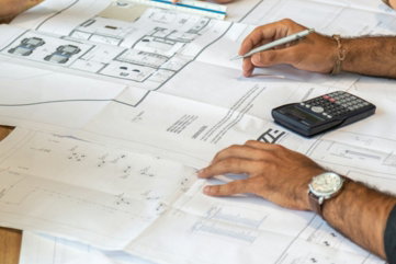 people-reviewing-architectural-blueprints-on-desk.jpg people reviewing architectural blueprints on desk